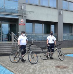 policjanci z rowerami służbowymi przed budynkiem komendy