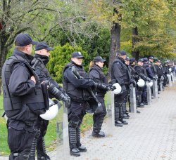 Policjanci w pełnym umundurowaniu z tarczami zabezpieczający marsz równości