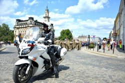 Policjant na służbowym motocyklu w tle sądecki ratusz