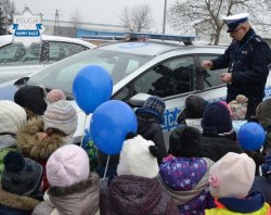 Policjant WRD prezentuje dzieciom radiowóz podczas dni otwarych komendy