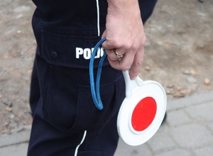 policjantka z tarczą do zatrzymywania pojazdu