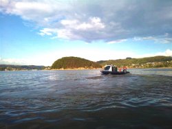policyjna łódź na jeziorze, w tle Małpia Wyspa