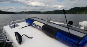 fragment policyjnej łodzi, w tle Jezioro Rożnowskie