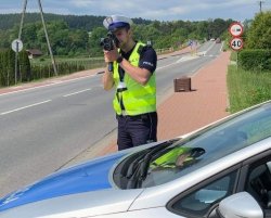 pomiar prędkości wykonywany laserowym miernikiem przez policjanta ruchu drogowego