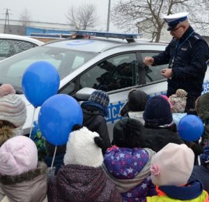 dni otwarte komendy - policjant ruchu drogowego przy radiowozie oraz grupa dzieci