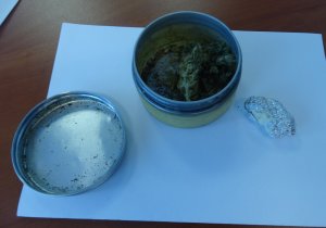 marihuana w metalowej puszce obok w folii aluminiowej amfetamina.