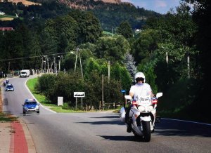 7. Pilotaż wyścigu - policjant na motocyklu w tle dwa radiowozy