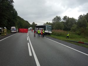 na drodze uszkodzony autobus, obok czerwony parawan i służby pracujące na miejscu zdarzenia