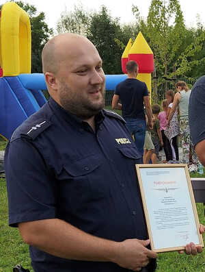 asp. Damian Janiczek podczas festynu, w dłoniach trzyma podziękowanie
