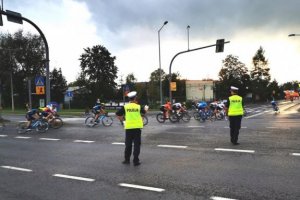 policjanci drogówki zabezpieczają przejazd zawodników podczas wyścigu kolarskiego