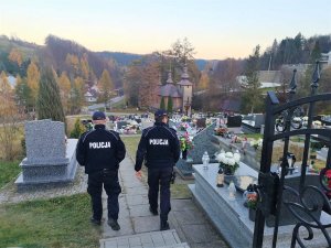 policjanci patrolują teren cmentarza