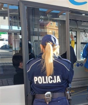umundurowana policjantka w pobliżu miejskiego autobusu.jpg