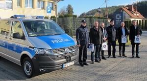 wspólne zdjęcie uczestników spotkania przy radiowozie