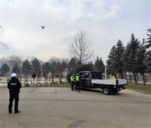 policjanci prowadzą kontrolę pojazdu, na niebie dron sterowany przez funkcjonariusza