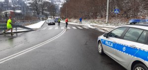 policjant wstrzymuje ruch samochodowy, by umożliwić bieg zawodnikom