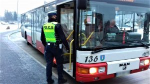 policjant drogówki podczas kontroli autobusu