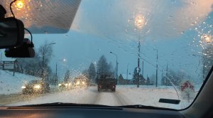 samochody jadące zaśnieżoną drogą w miejscowości Krzyżówka