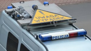 policyjny radiowóz, na dachu znak ostrzegawczy z napisem &#039;uwaga wypadek&#039;