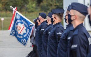 policjanci stojący w rzędzie, dalej sztandar