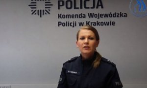 policjantka, za nią napis Komenda Wojewódzka Policji w Krakowie
