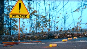 kadr z filmu instruktażowego  - na jezdni ustawiony znak ostrzegawczy z napisem uwaga wypadek