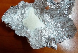 biały proszek (amfetamina) na kawałku folii aluminiowej - zdjęcie ilustracyjne