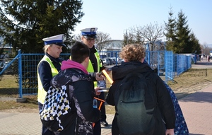 policjanci przekazują uczniom elementy odblaskowe