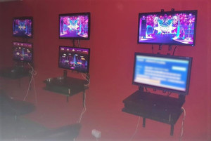 wnętrze salonu gier, czerwone ściany, kilka maszyn do gier