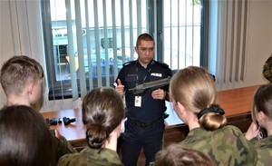 policjant prezentuje uczniom broń służbową