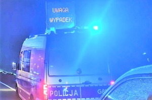 zdjęcie ilustracyjne, policyjny radiowóz, błyskające lampy, na dachu napis Uwaga wypadek