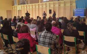 uczestnicy prelekcji, przemawia dyrektor szkoły obok umundurowani policjanci