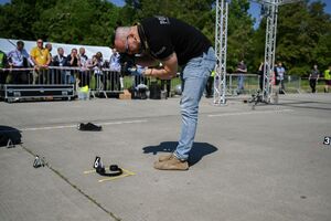 technik kryminalistyki wykonuje zdjęcie leżących na ziemi słuchawek