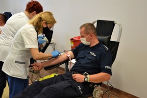 umundurowany funkcjonariusz jest przygotowywany do pobrania krwi przez pracownicę RCKiK