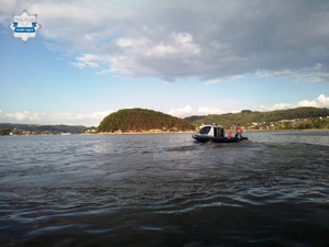 policyjna łódź na Jeziorze Rożnowskim, w tle Małpia Wyspa