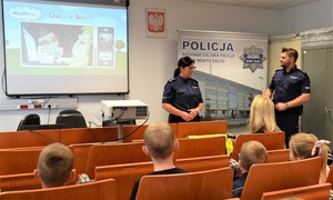 policjanci prewencji oraz uczestnicy spotkania w sali opraw, rzutnik wyświetla film edukacyjny