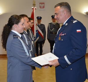 8. policjantka odbiera gratulacje od komendanta Ledziona