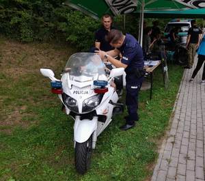 4. umundurowani policjanci, oraz mały uczestnik pikniku na motocyklu policyjnym