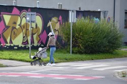 kobieta z dzieckiem w wózku przekracza przejście dla pieszych