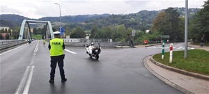 rejon mostu w Piwnicznej-Zdroju, policjant drogówki, obok motocykl służbowy