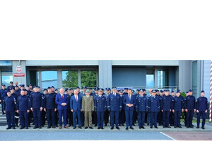 goście i policjanci przed komendą