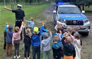 17. policjant i uczniowie obok radiowozu — kopia