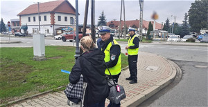 15. policjanci ruchu drogowego wręczają kobiecie element edblaskowy