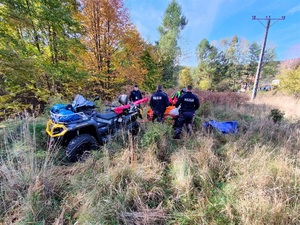 policjanci i ratownik GOPR, poszkodowany mężczyzna na przyczepce quada