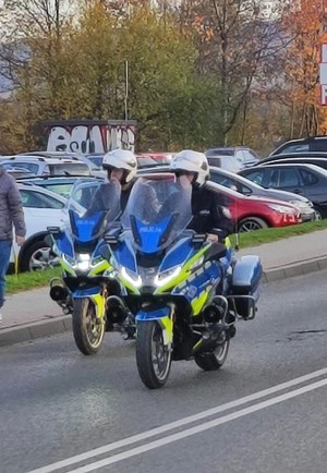 policjanci ruchu drogowego przejeżdżają na służbowych motocyklach w rejonie cmentarza