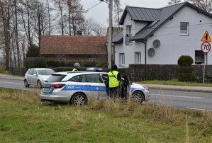 2. policjanci w kamizelkach odblaskowych przy radiowozie