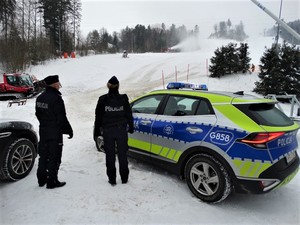 policjanci prewencji przy radiowozie na parkingu stacji narciarskiej