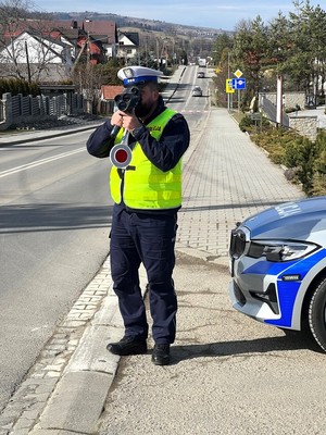umundurowany policjant drogówki używa laserowego miernika prędkości