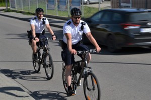 funkcjonariusze prewencji na rowerach jadą po ulicy