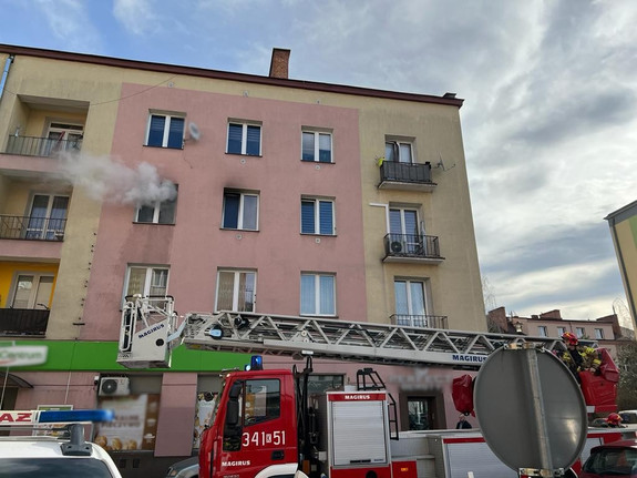 wóz straży pożarnej przed budynkiem, z okna na drugim piętrze wydobywa się dym - źródło KM PSP w N. Sączu