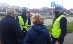 policjanci ruchu drogowego przekazują odblaski seniorom